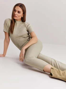 Beige high-waisted pants with clutch
