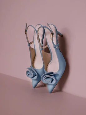 Light blue leather pumps with a flower detail and an open heel