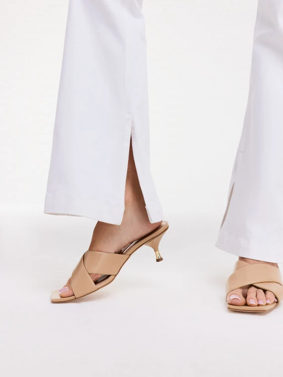 Beige flip-flops with decorative gold element on the heel
