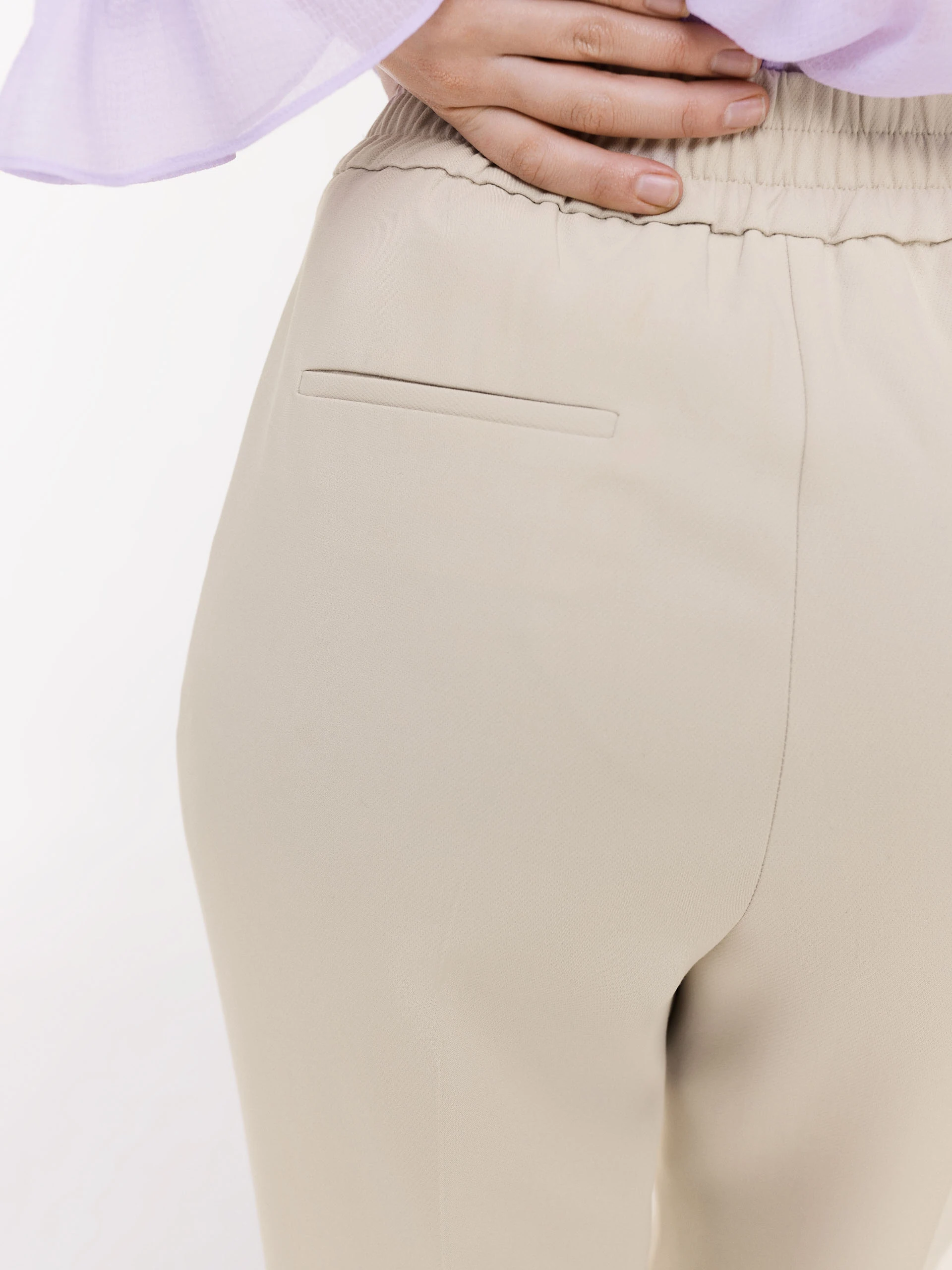 Beige cigarette pants with decorative buttons