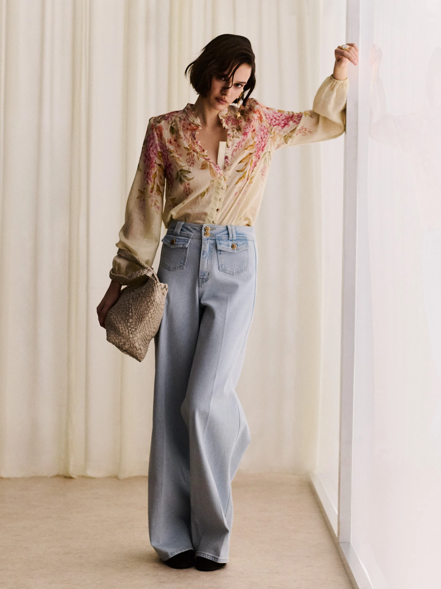 Light-colored wide-leg jeans with decorative buttons