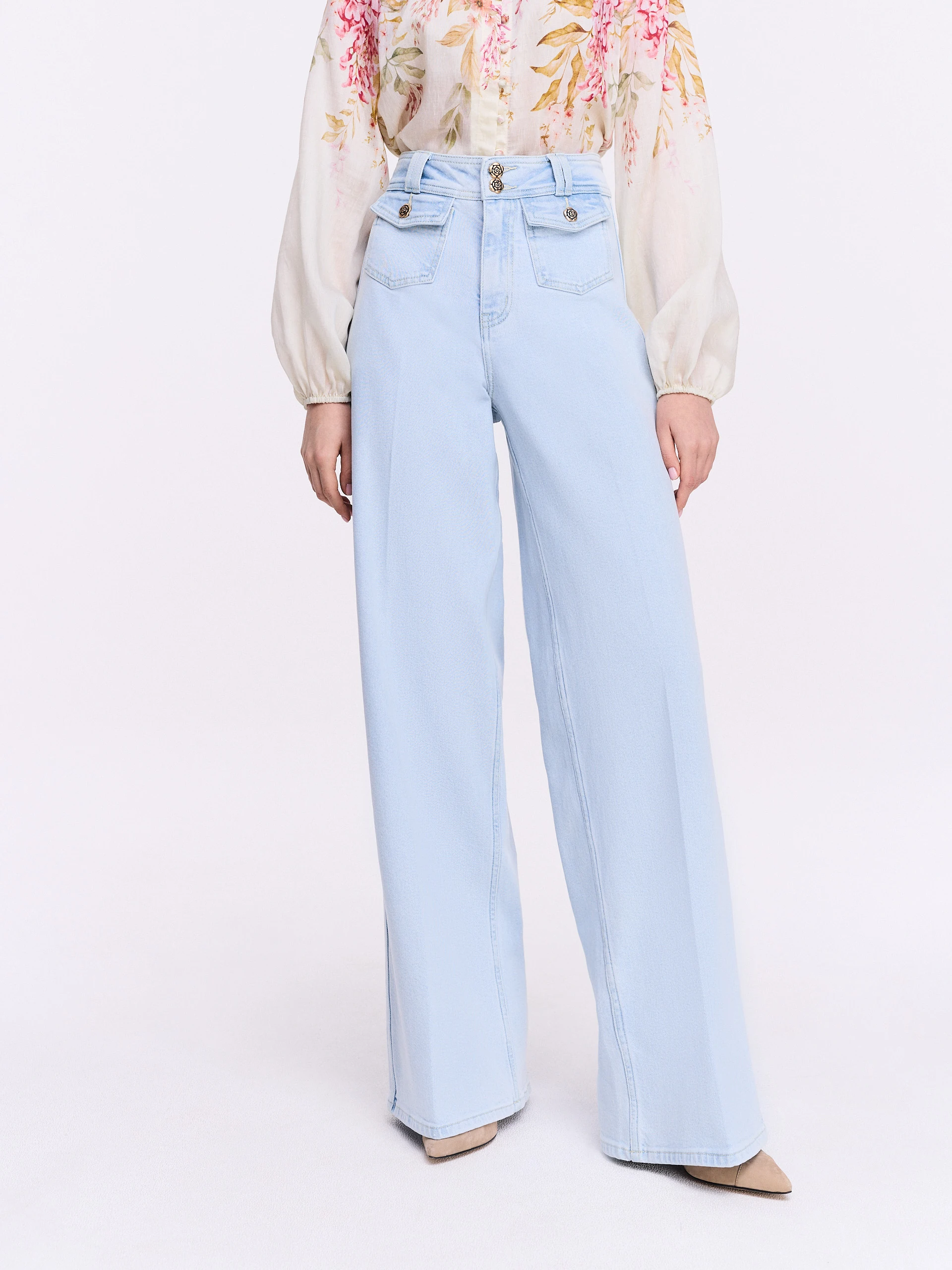 Light-colored wide-leg jeans with decorative buttons