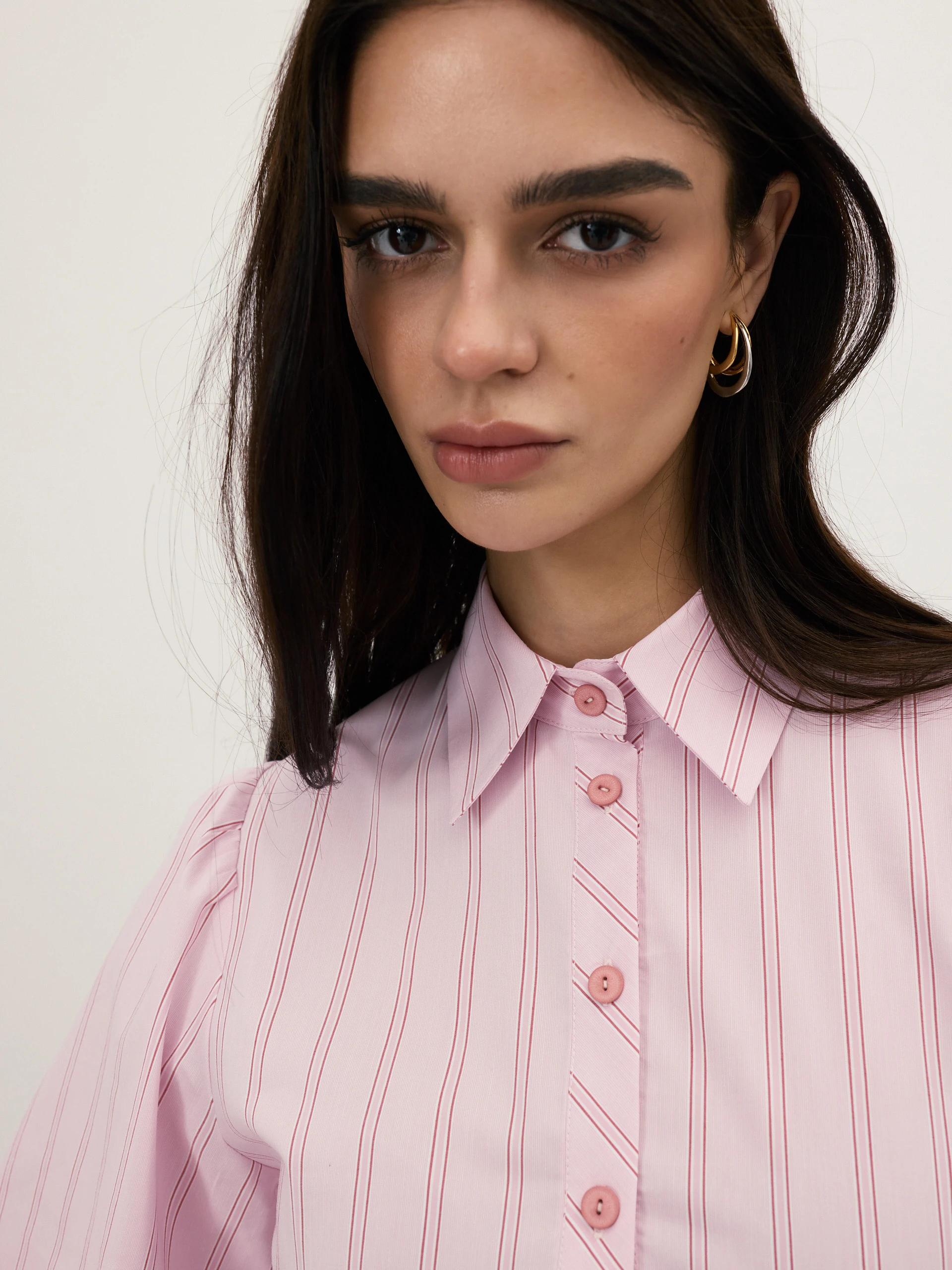 A light pink, fitted, ribbed blouse