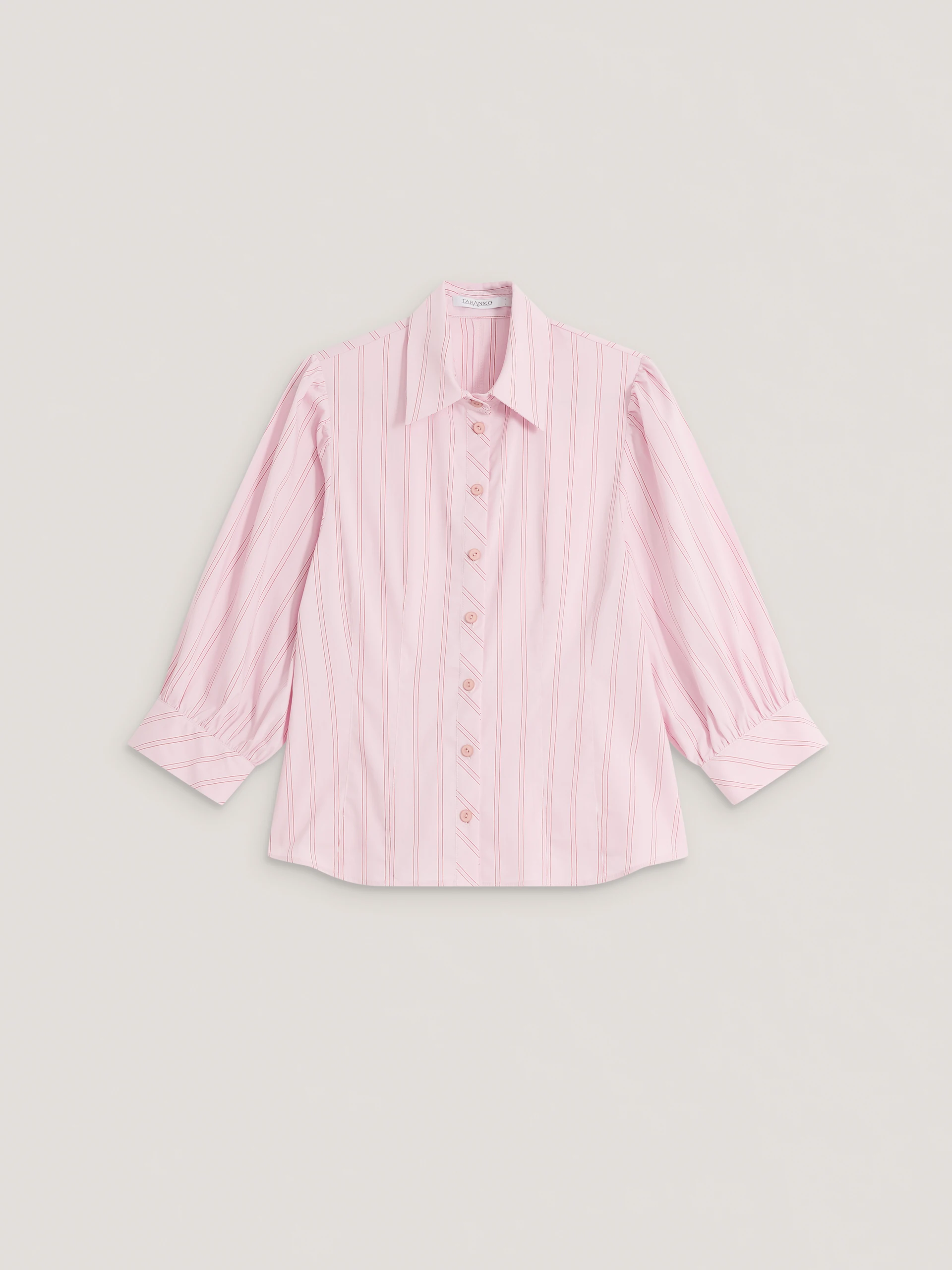 A light pink, fitted, ribbed blouse