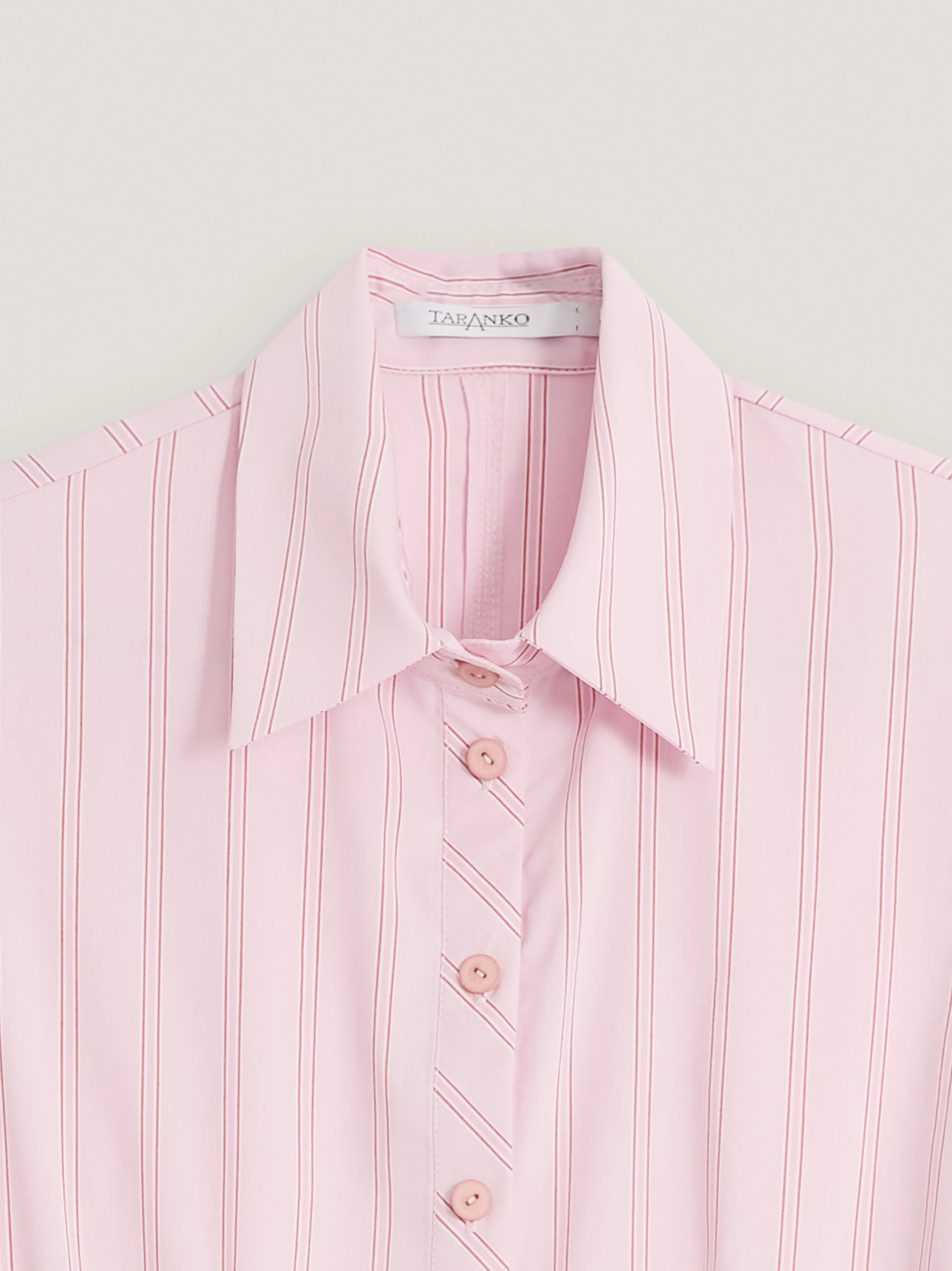 A light pink, fitted, ribbed blouse