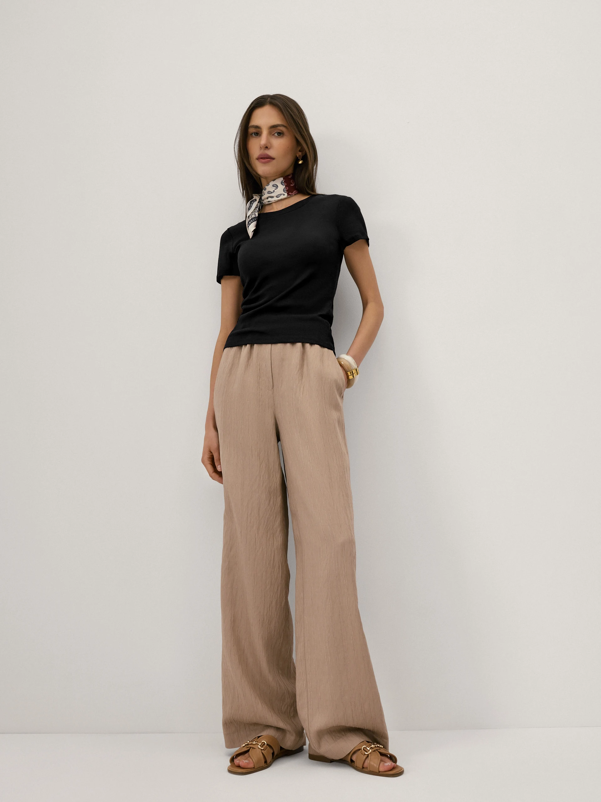 Beige high-waisted trousers with a subtle ribbed pattern