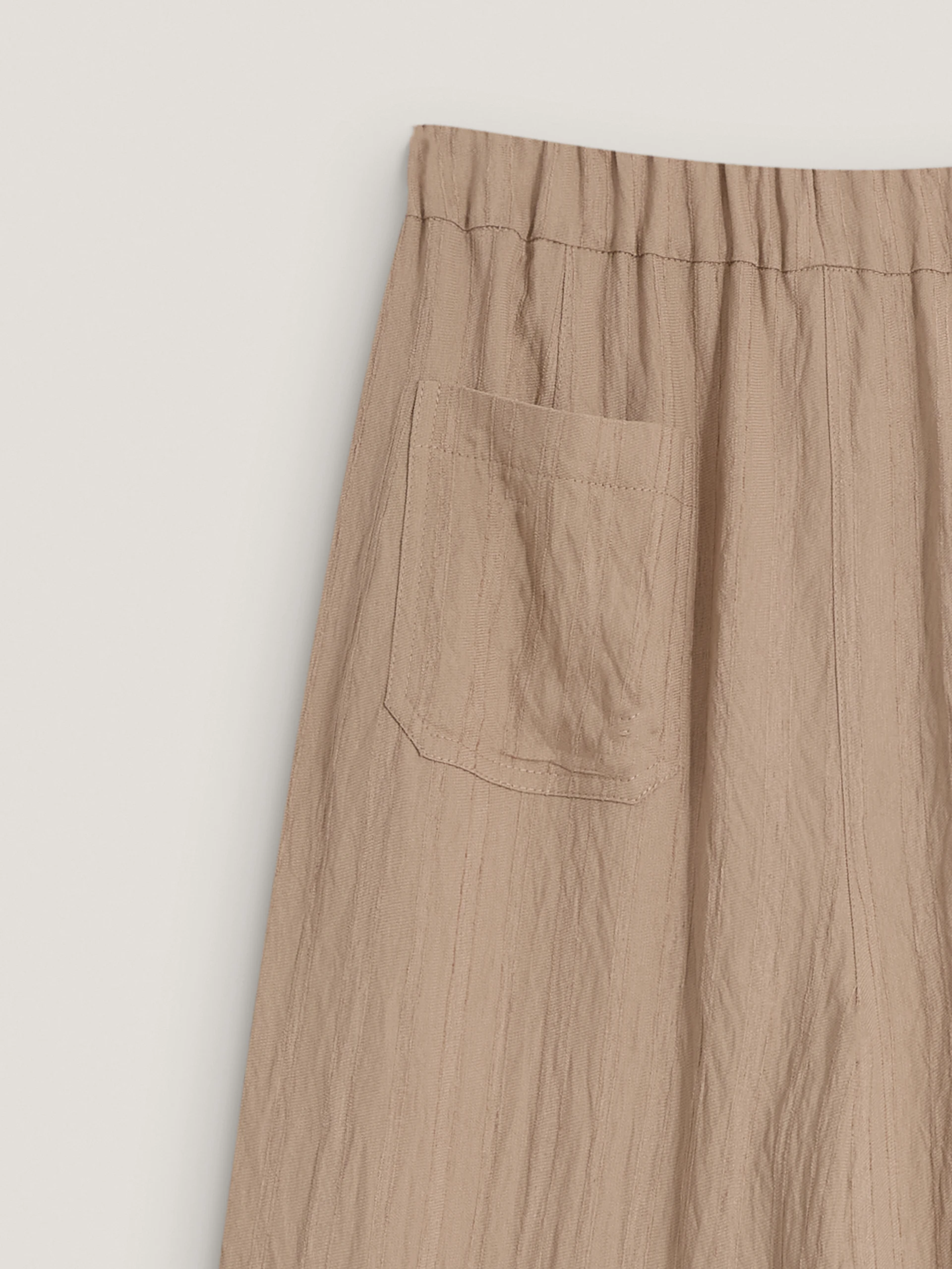 Beige high-waisted trousers with a subtle ribbed pattern
