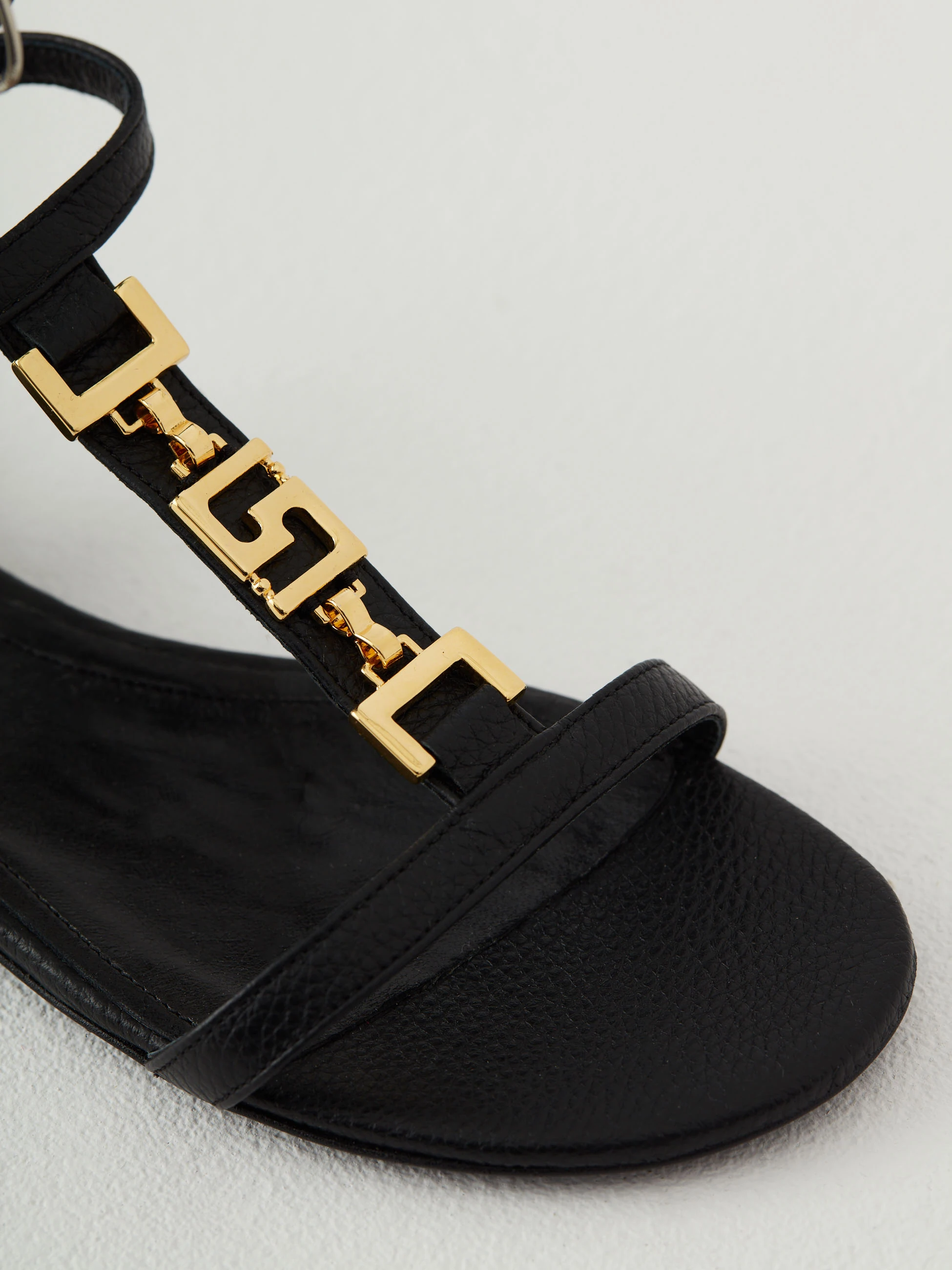 Black leather sandals with gold elements