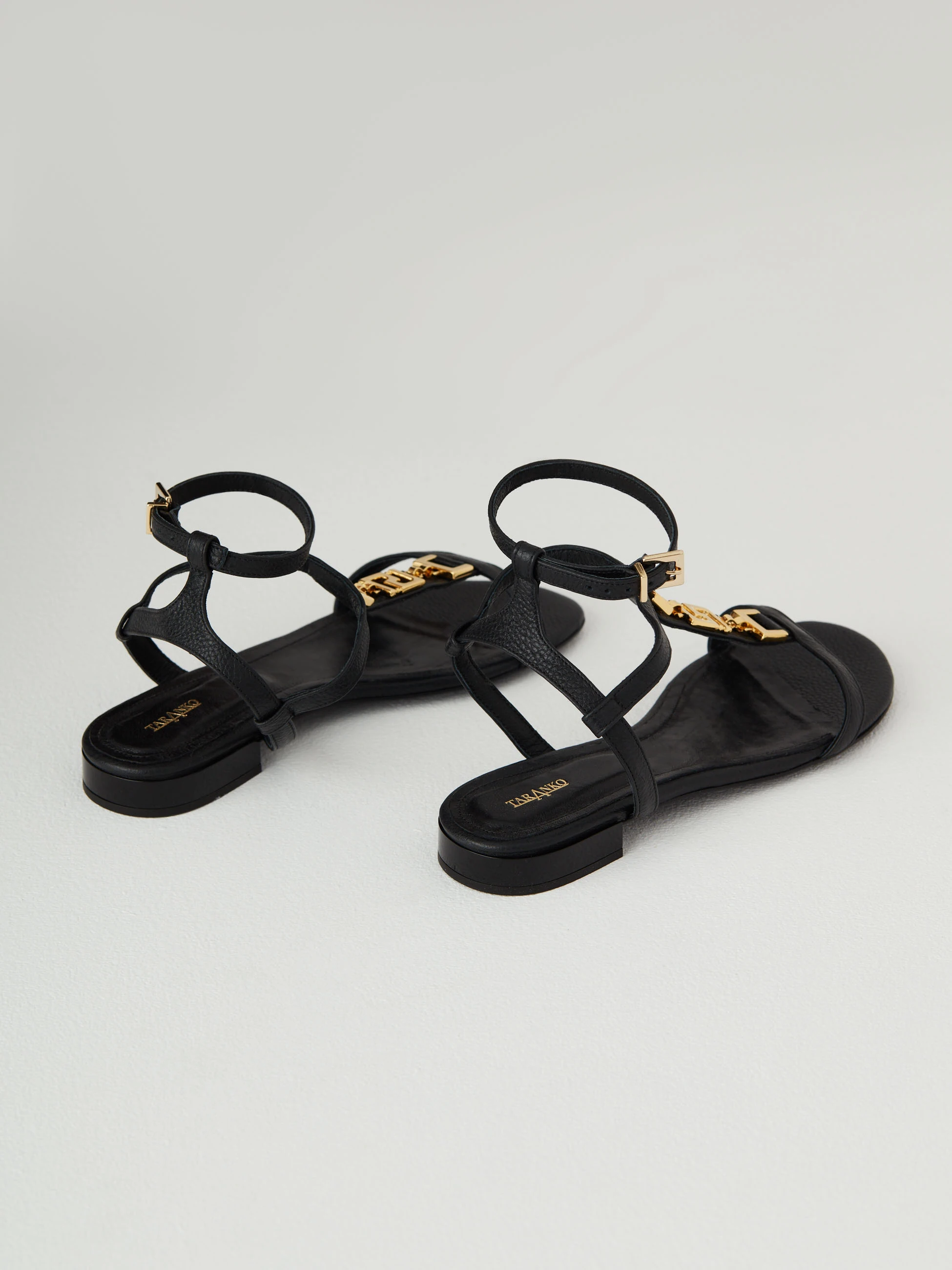 Black leather sandals with gold elements