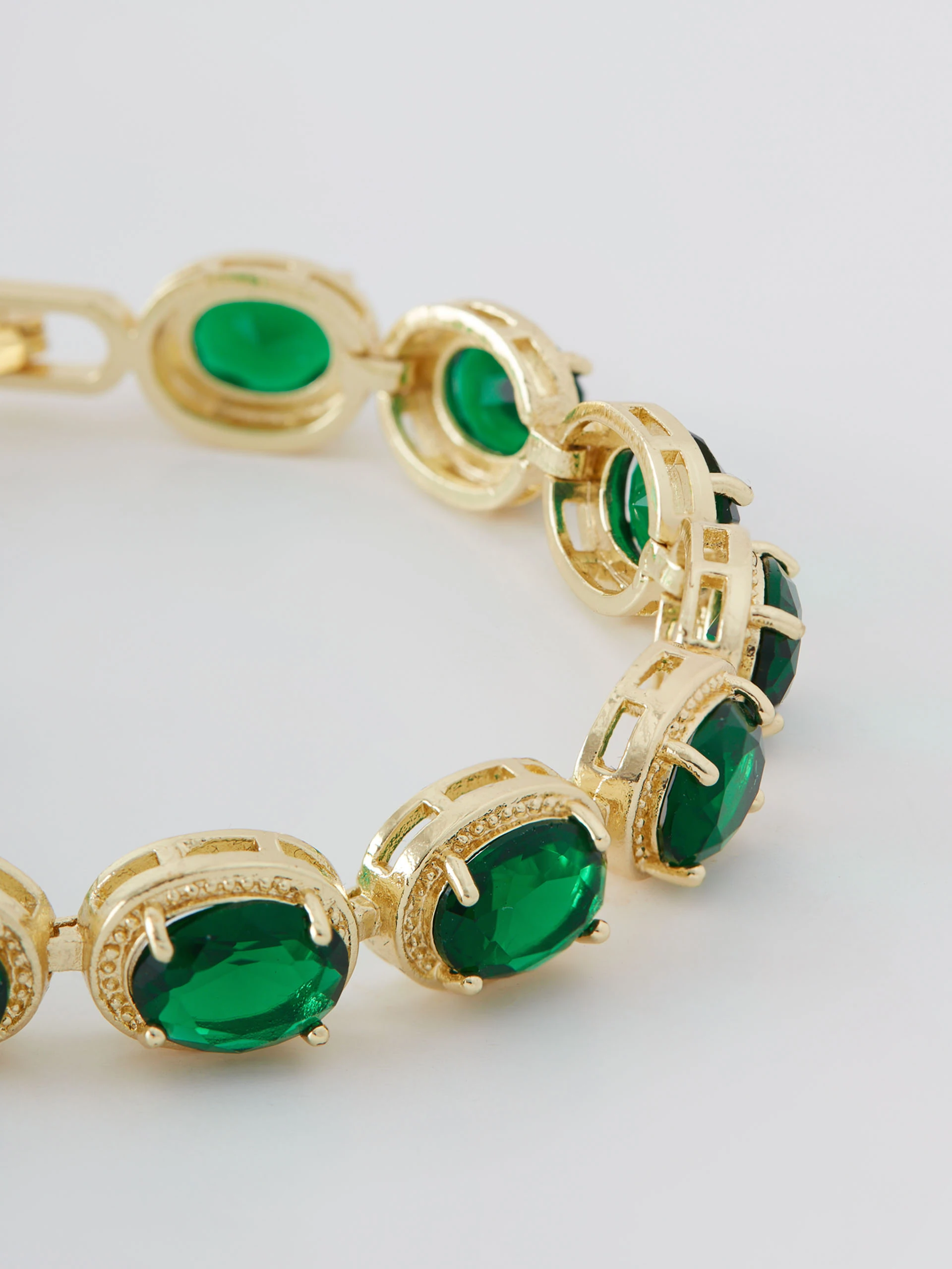 Gold-tone copper bracelet with green zircons