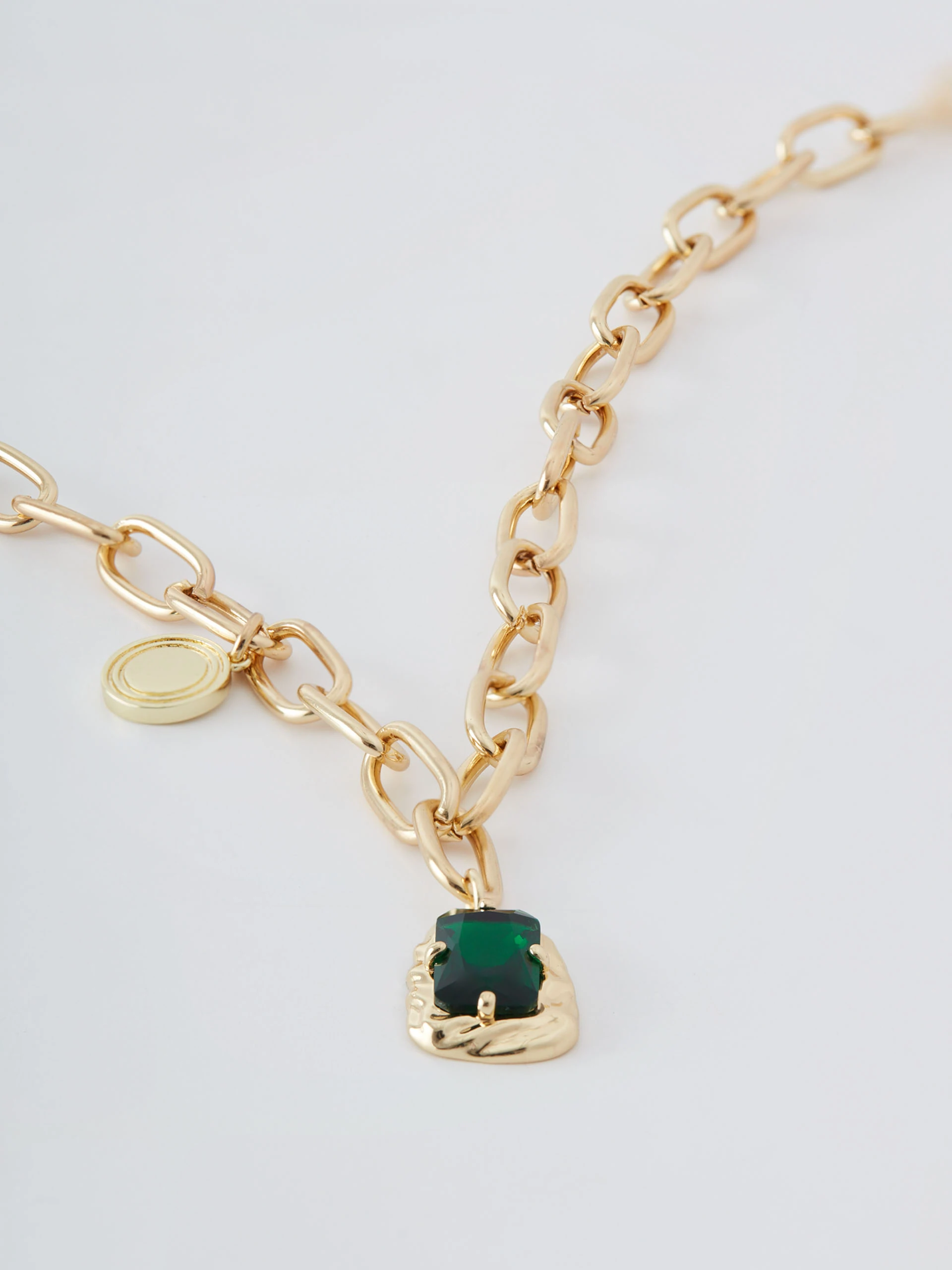 Gold colored necklace with green zirconia