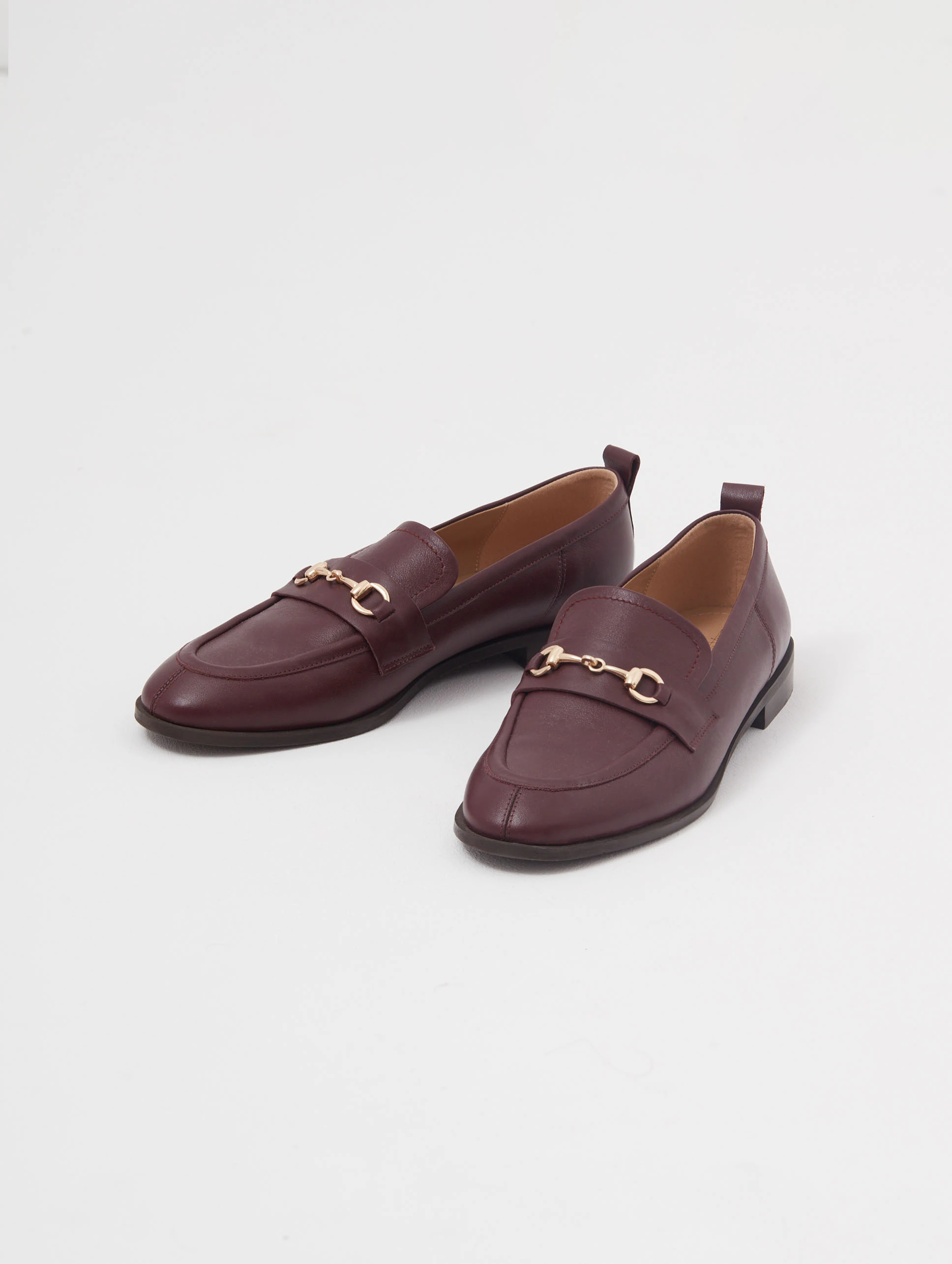 Burgundy leather moccasins with metal buckles