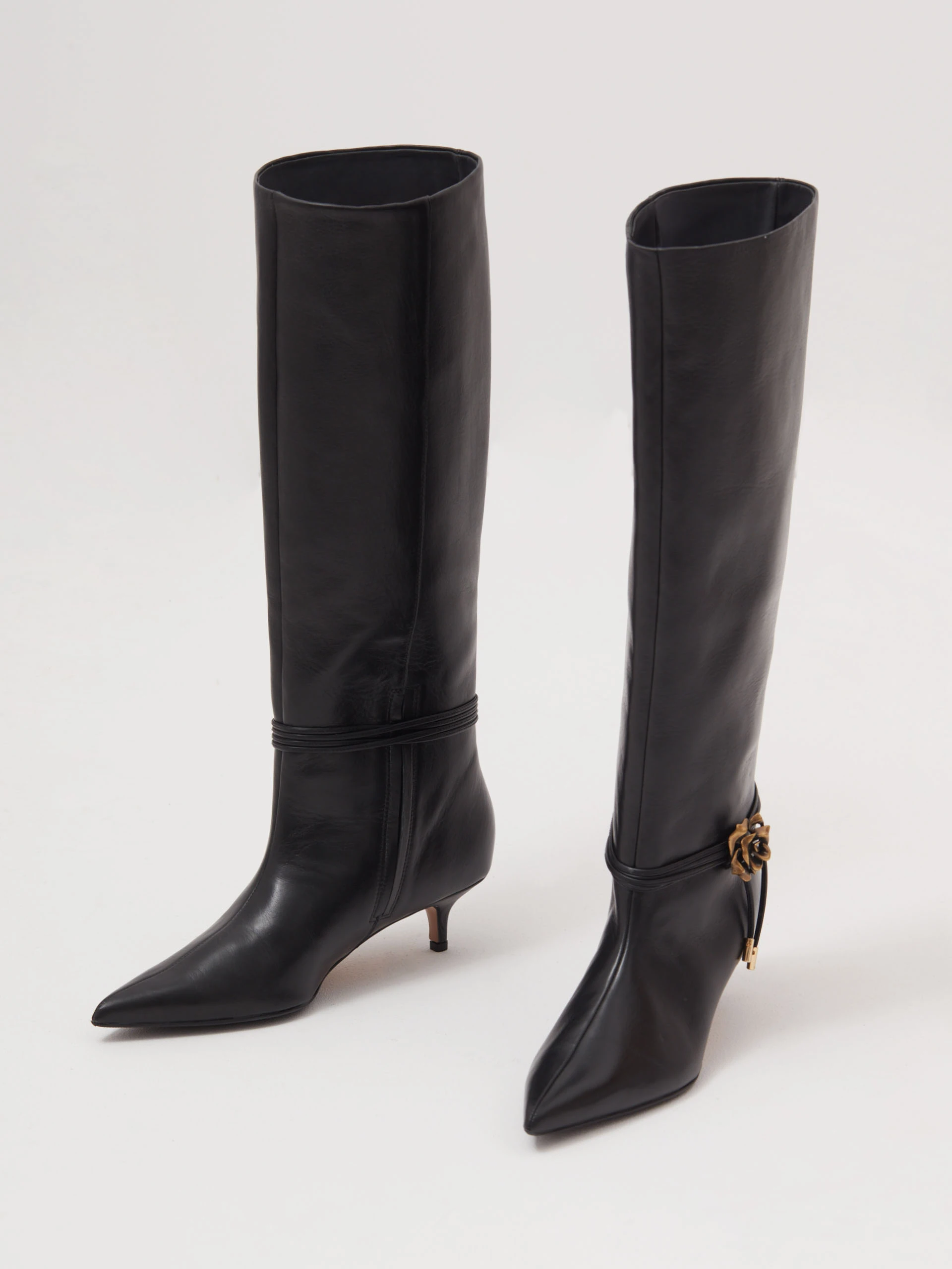 Black leather boots with decorative rose on the strap