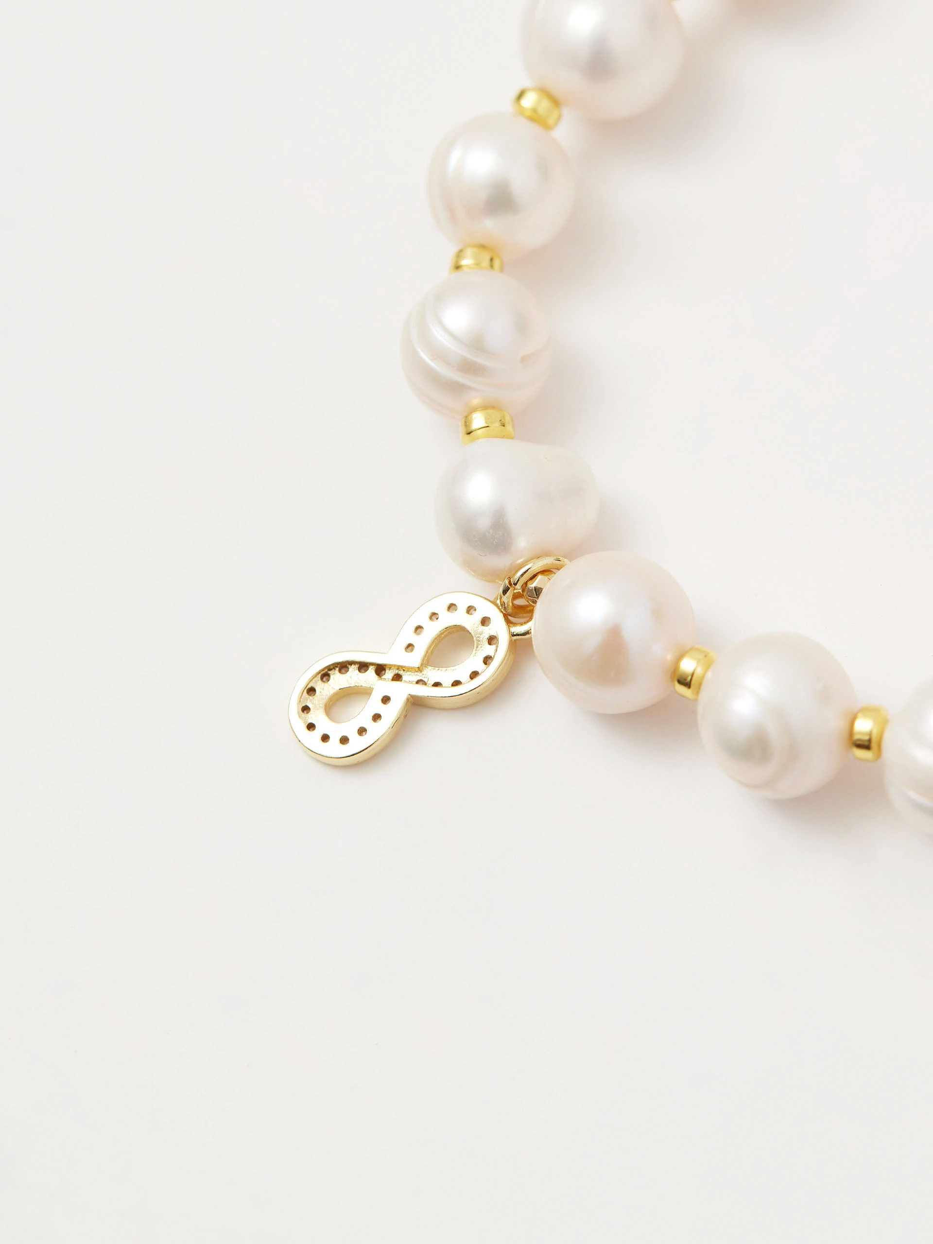 Pearl bracelet with infinity symbol pendant