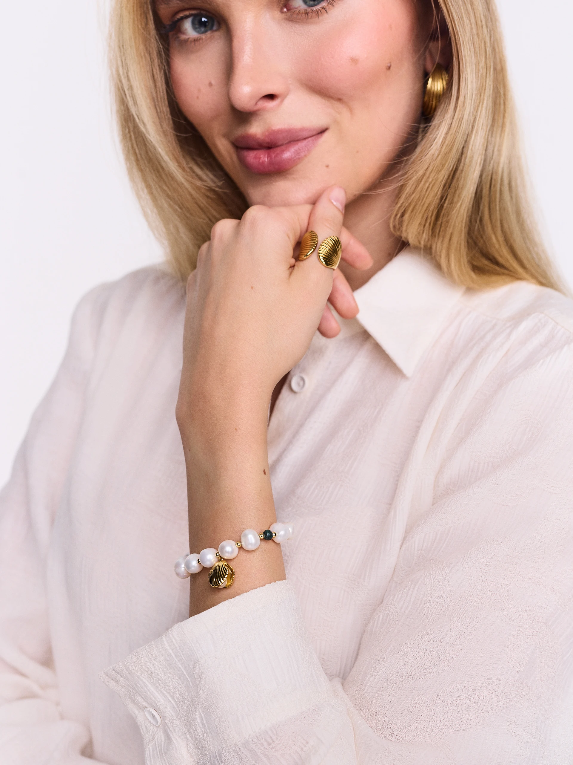 A pearl bracelet with a seashell-shaped charm
