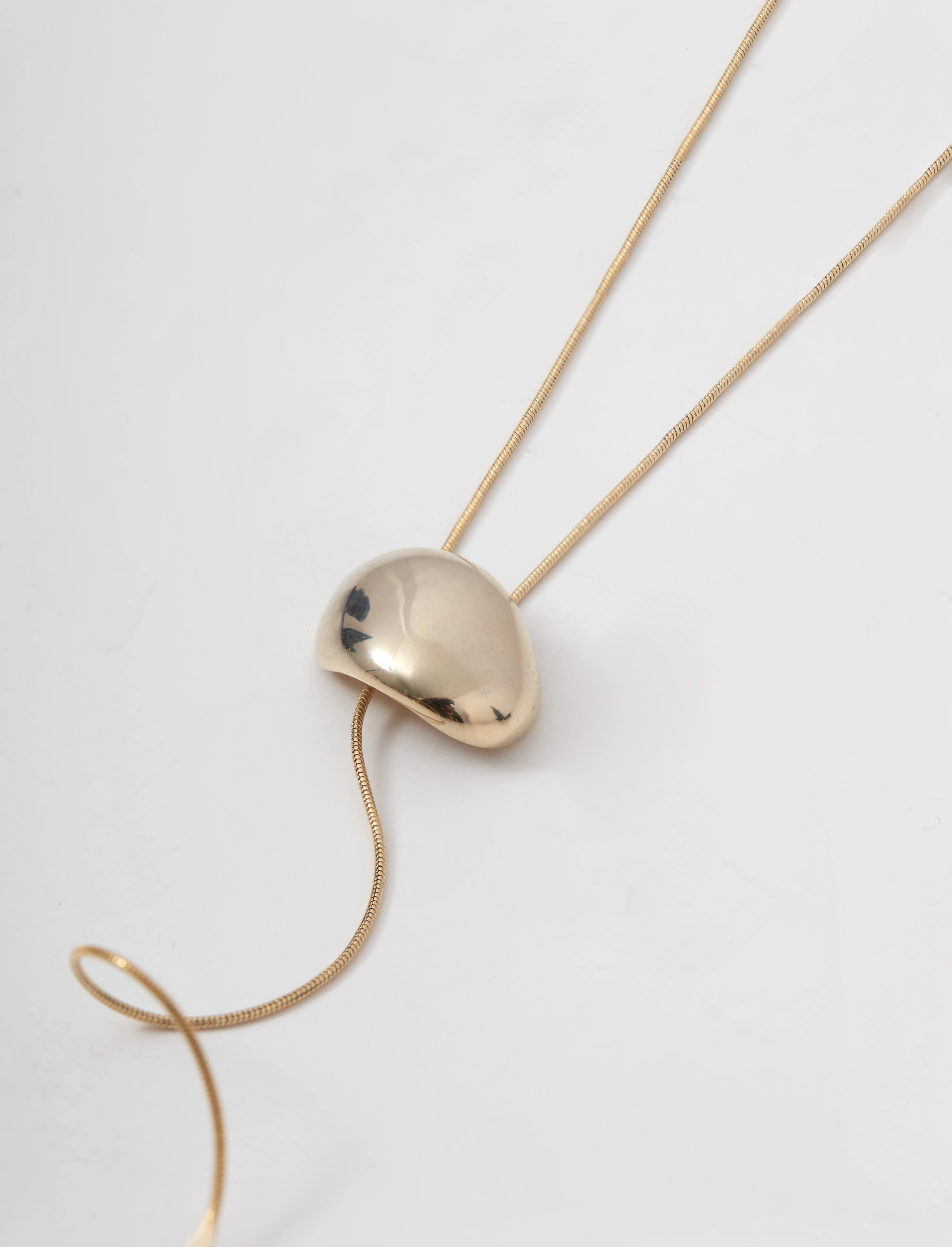 A gold-colored necklace with a pendant and a clasp