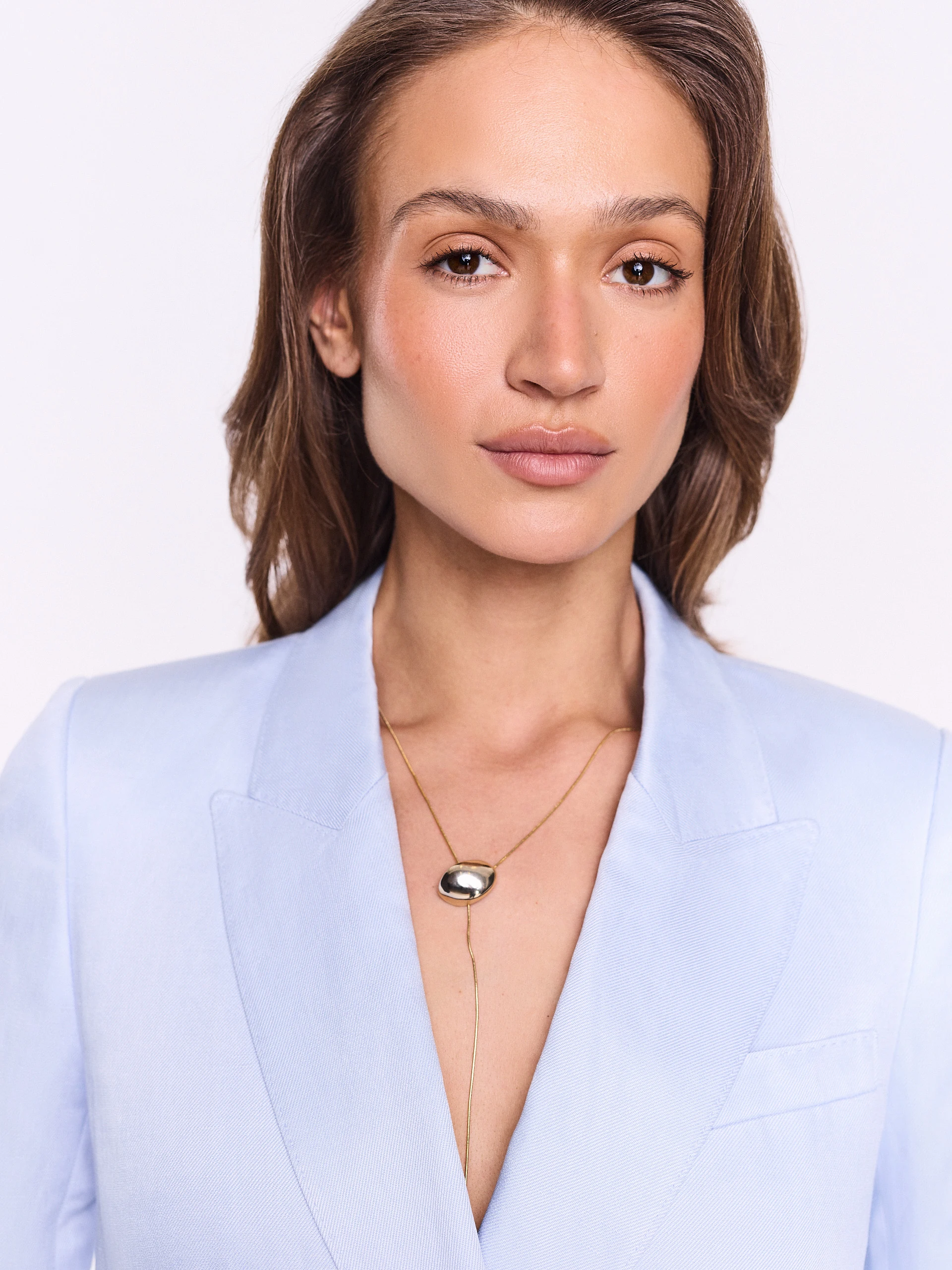 A gold-colored necklace with a pendant and a clasp