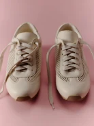 Skórzane kremowe sneakersy z ozdobnymi przywieszkami