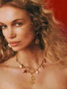 A gold-colored necklace with decorative pendants featuring a natural pearl