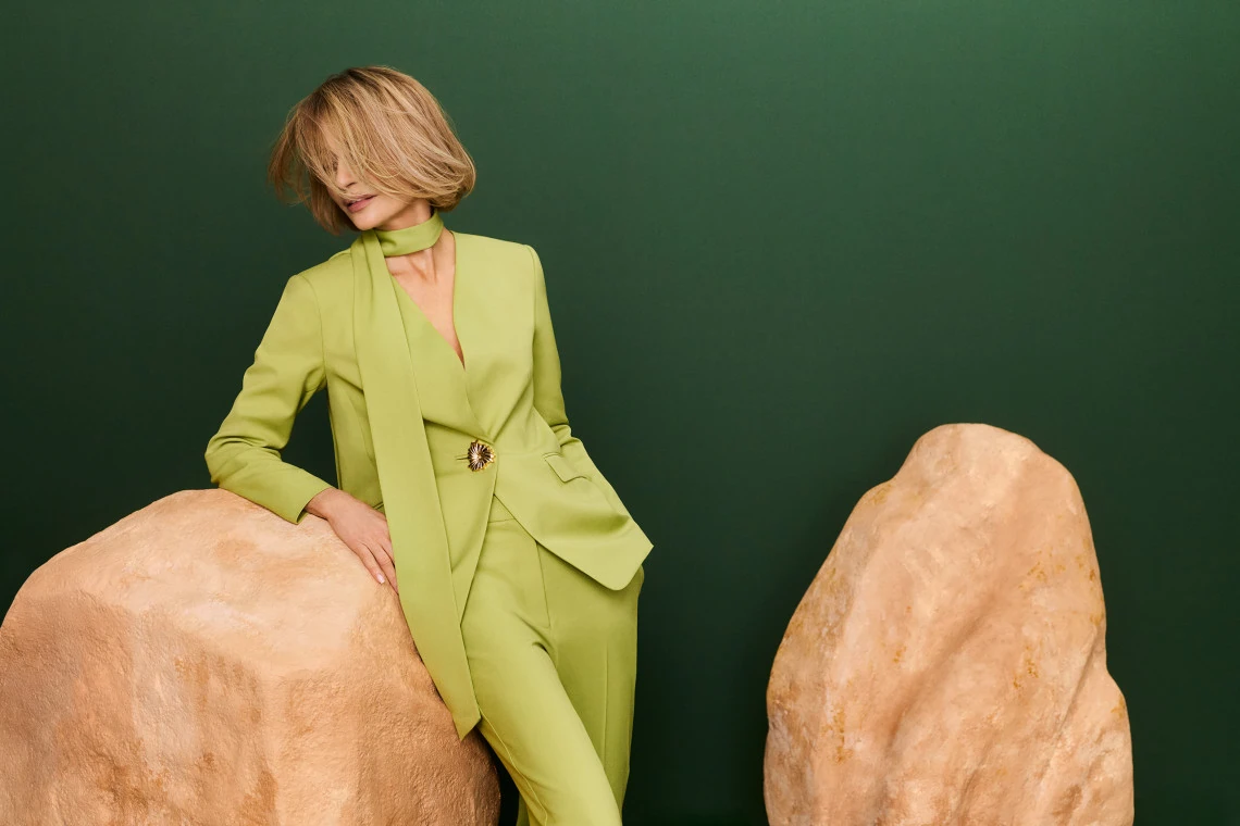 Green jacket with a sash and a jeweled button