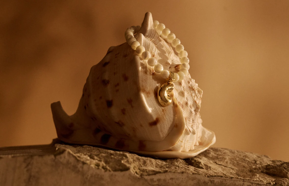 A mother-of-pearl necklace with a gold-plated pendant