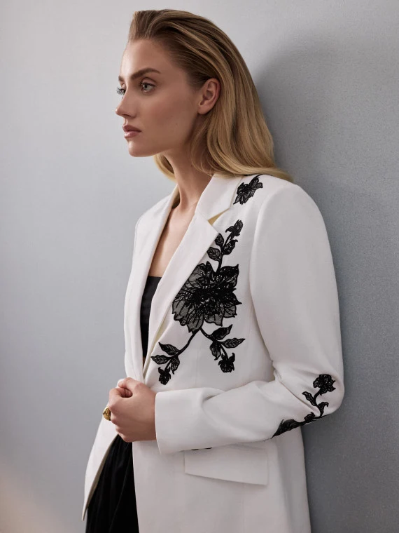 A white blazer with lace detailing and linen accents