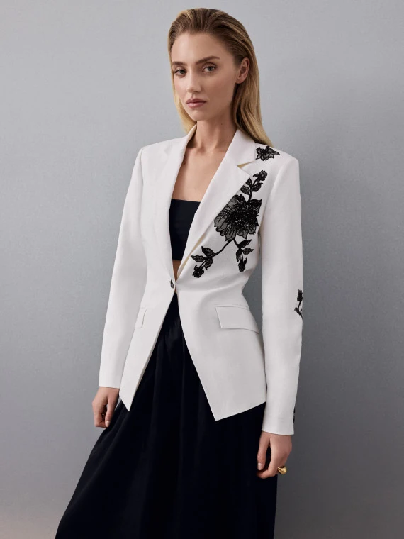 A white blazer with lace detailing and linen accents