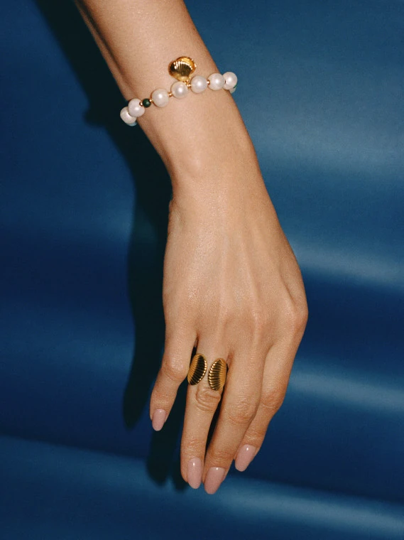 A pearl bracelet with a seashell-shaped charm