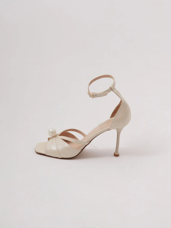Cream-colored heeled sandals with pearl detailing