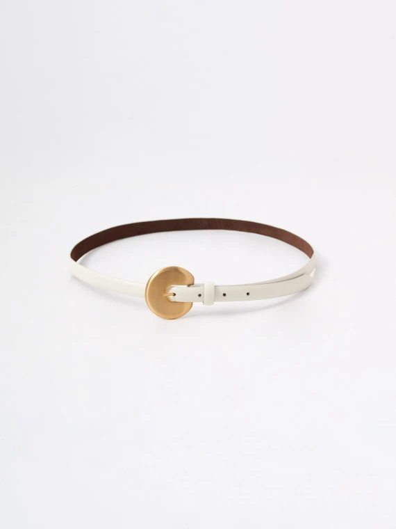 A thin, creamy-colored strap made of bombato leather