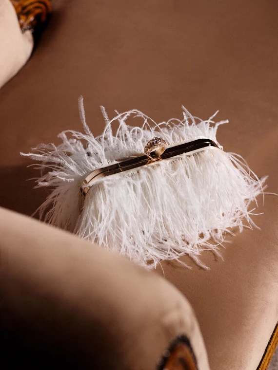 A small cream-colored handbag embroidered with feathers