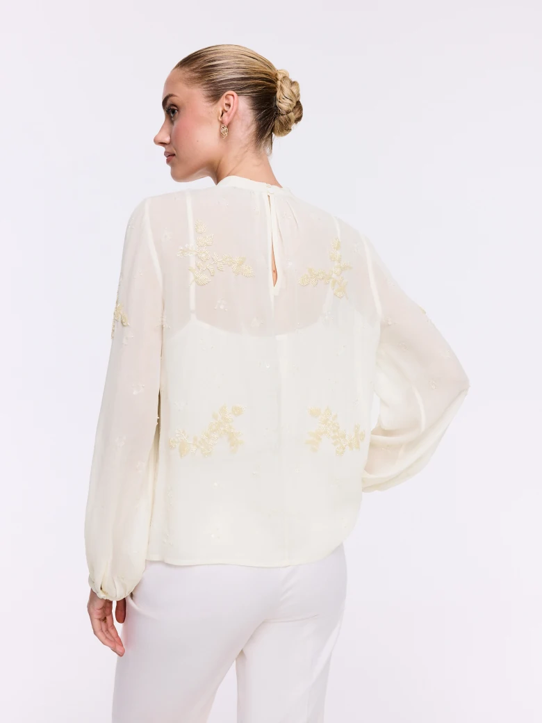 An elegant blouse with decorative appliqués