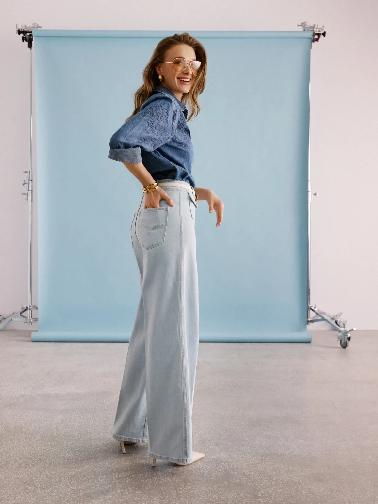 Light-colored wide-leg jeans with decorative buttons