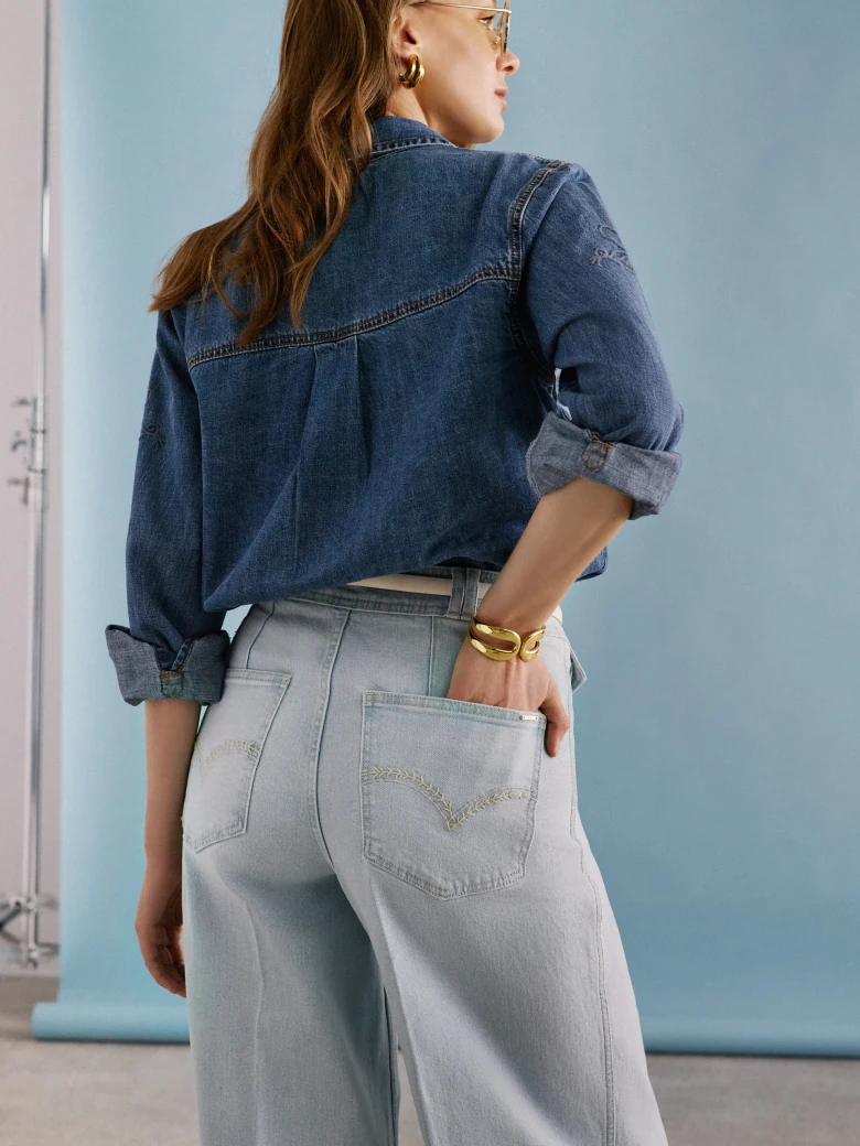 Light-colored wide-leg jeans with decorative buttons