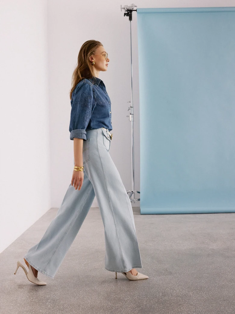 Light-colored wide-leg jeans with decorative buttons