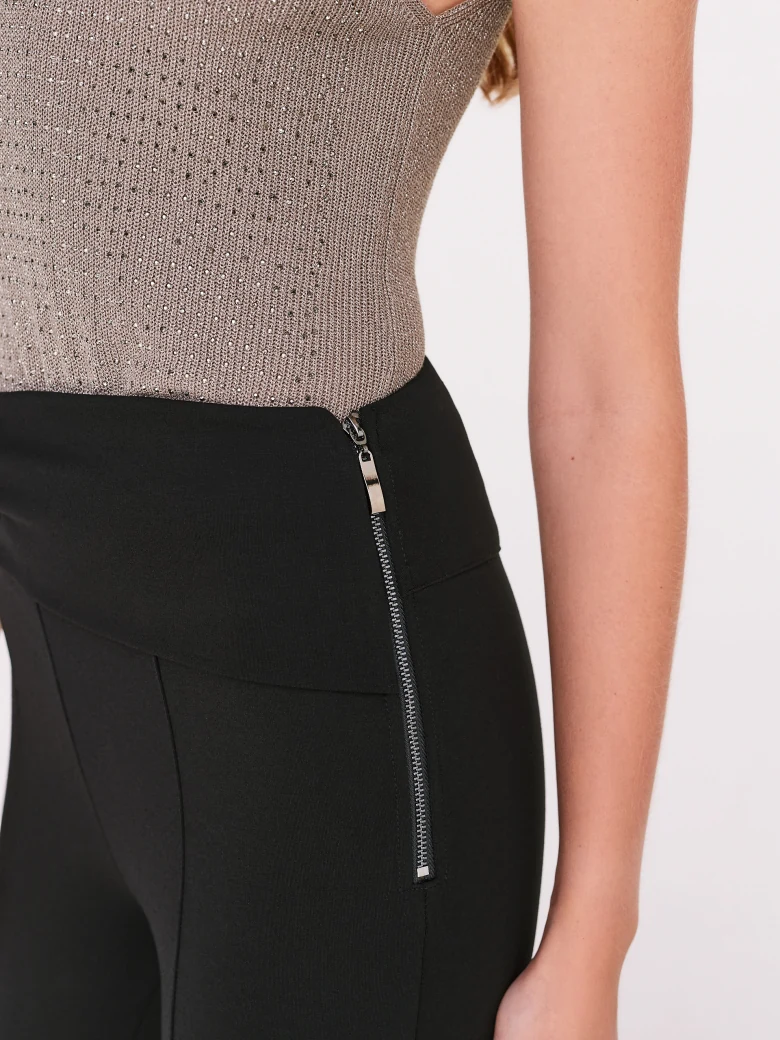 Black high-waisted pants with a clutch