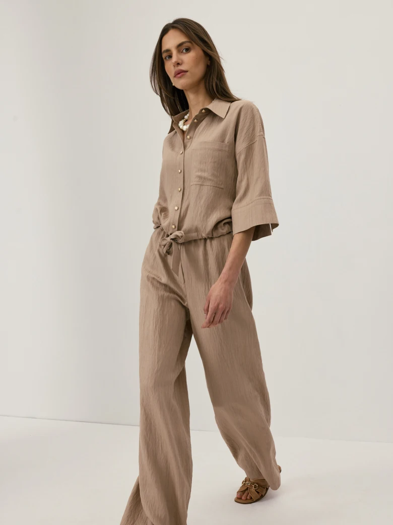Beige high-waisted trousers with a subtle ribbed pattern