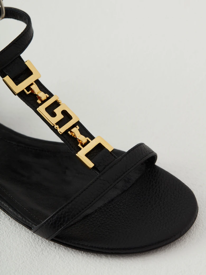 Black leather sandals with gold elements