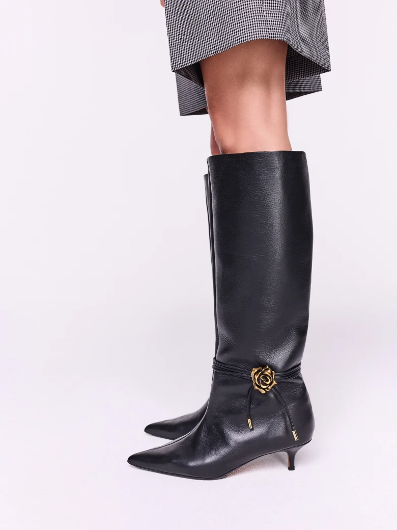 Black leather boots with decorative rose on the strap