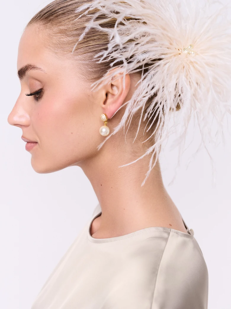 A cream-colored brooch made of bird feathers