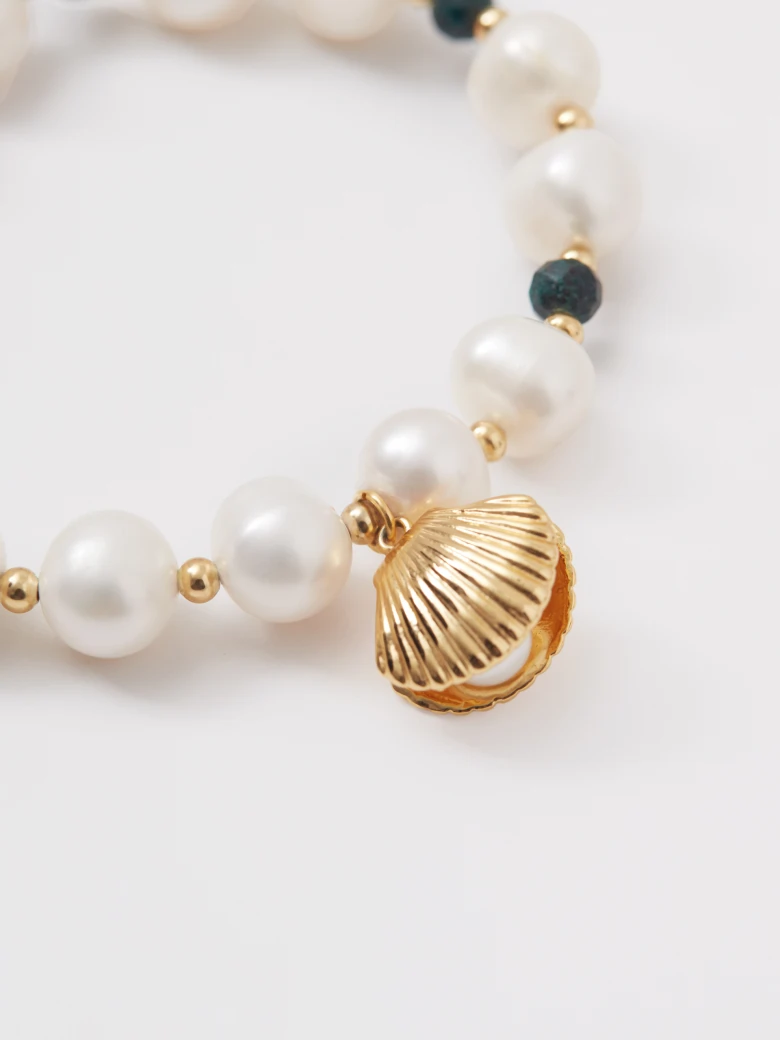A pearl bracelet with a seashell-shaped charm