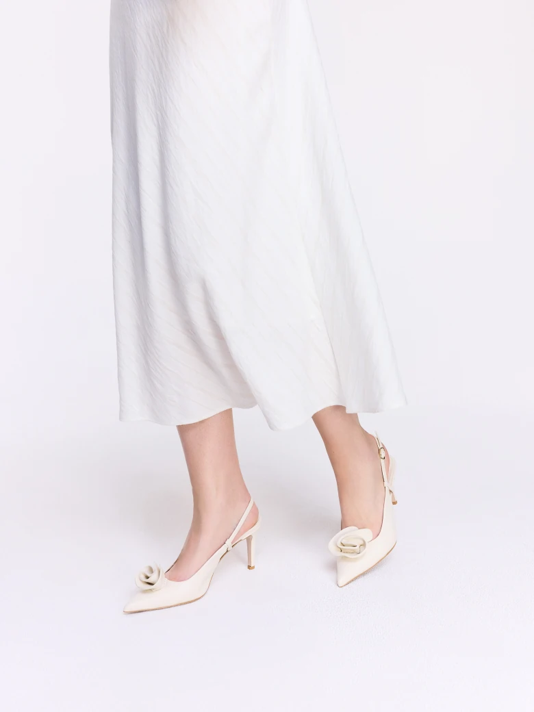 Cream-colored leather pumps with a flower