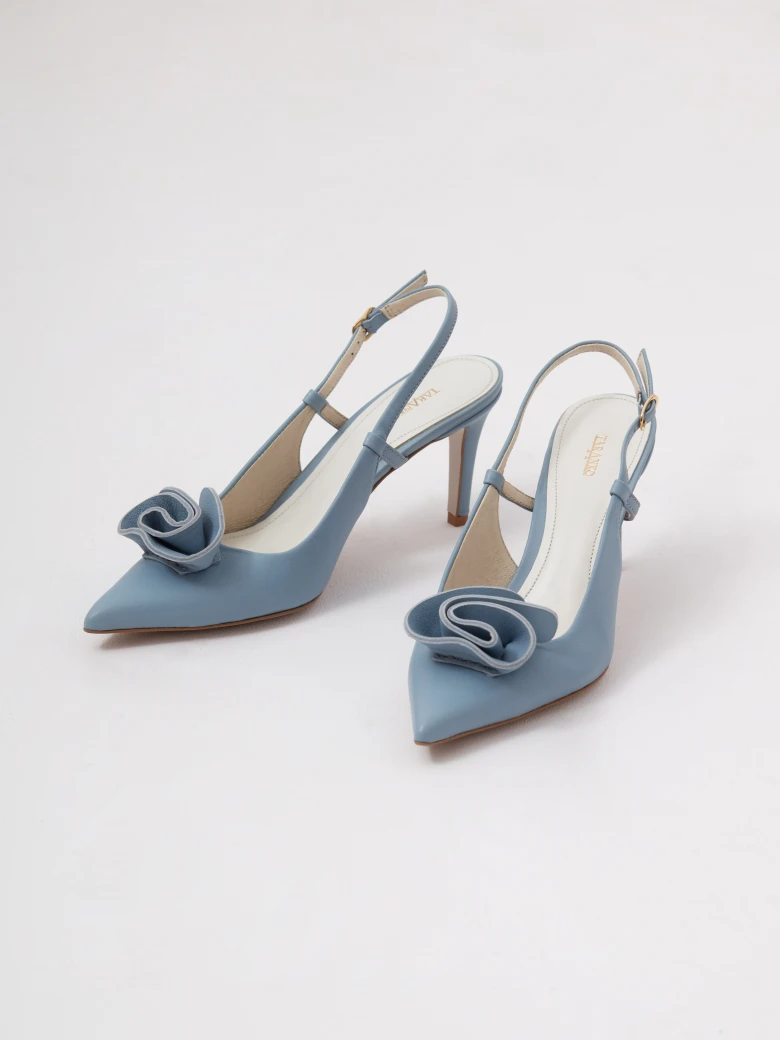 Light blue leather pumps with a flower detail and an open heel